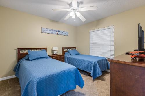 a bedroom with two beds and a ceiling fan at Estuary Views Close to Pool Amenities Walk to Beach 9-505 in New Smyrna Beach
