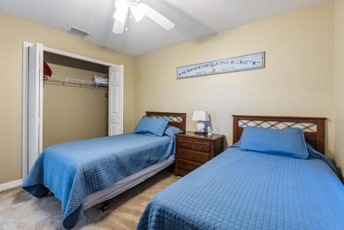 two beds in a bedroom with blue comforter at Estuary Views Close to Pool Amenities Walk to Beach 9-505 in New Smyrna Beach