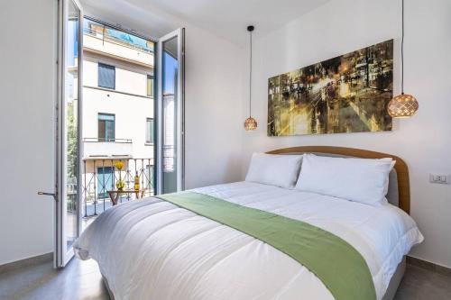 Un dormitorio con una cama y una ventana grande. en [Navigli-Duomo] Sweet22 Luxury OpenSpace, en Milán