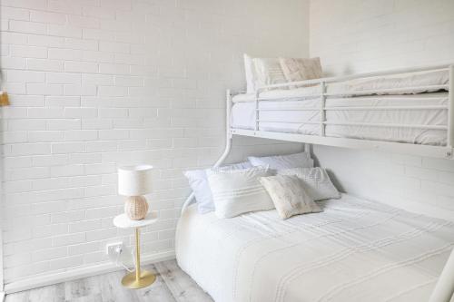 Dormitorio blanco con cama con sábanas y almohadas blancas en The Blue Whale - Sea View Apartment, en Eden