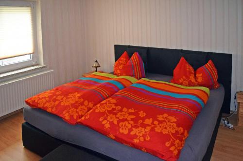 a large bed with a colorful blanket and pillows at Ferienwohnung Bömitz in Bömitz