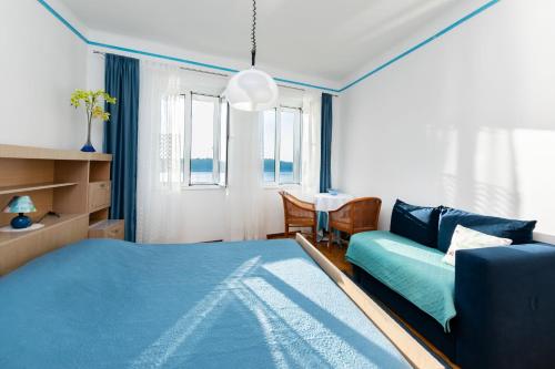 a bedroom with a blue bed and a couch at Rooms Marica B in Rab