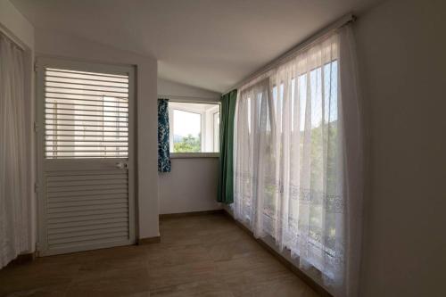 a room with a window and a door with curtains at Apartmán Michal in Bilice