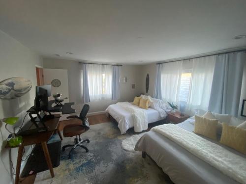 a bedroom with two beds and a desk with a computer at Work and Gym Hideaway in San Jose