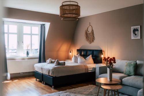 Luga Homes - Stadthaus في لايبزيغ: غرفة نوم بسرير واريكة