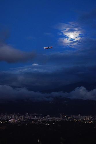 an airplane is flying in the sky with the moon at GREEN APARTMENT "el bosque" in Girón