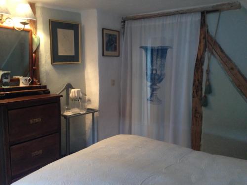 a bedroom with a bed and a dresser and a television at All Seasons Bed & Breakfast in Kerpen