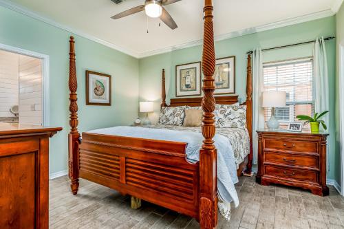 a bedroom with a four poster bed and a ceiling fan at Dauphin Island Beach Club 106A in Dauphin Island