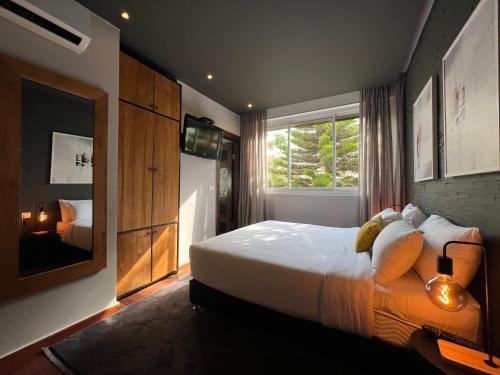 Un dormitorio con una cama grande y una ventana en Beer Garden Hotel, en Tel Aviv