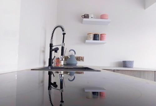 a kitchen counter with a sink with a tea kettle on it at The Hideout in Newry
