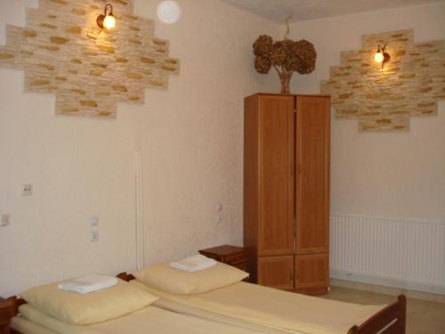 1 dormitorio con 2 camas y armario de madera en Pokoje Gościnne IRGA Apartamenty, en Starogard Gdański
