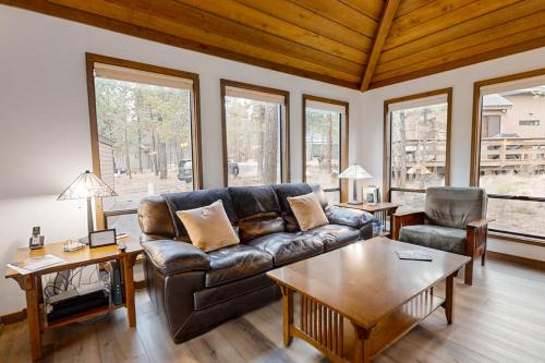 a living room with a leather couch and a table at Jackalope Manor in Sunriver