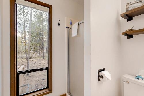 a bathroom with a toilet and a window at Jackalope Manor in Sunriver