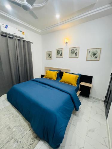 a blue bed with yellow pillows in a bedroom at Magnifique appartement meublé 2 chambres in Lomé