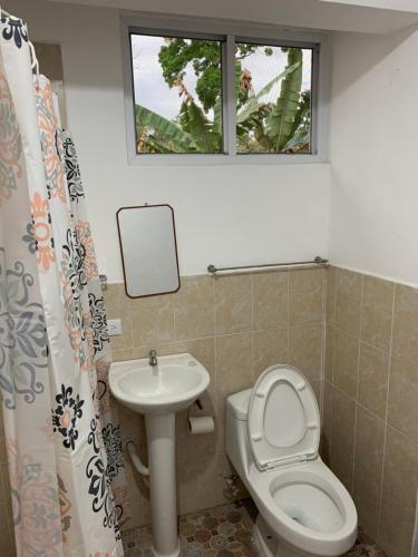 a bathroom with a toilet and a sink and a window at Apartamento Tulül in San Martín Zapotitlán