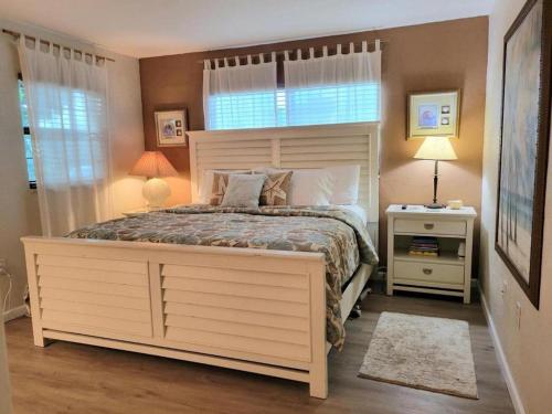 - une chambre avec un grand lit blanc et une fenêtre dans l'établissement Hacienda del Sol II - 103, à New Smyrna Beach