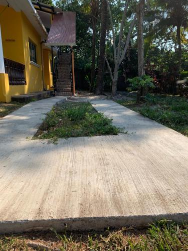 a sidewalk in front of a yellow house with a staircase at Apartamento Tulül in San Martín Zapotitlán