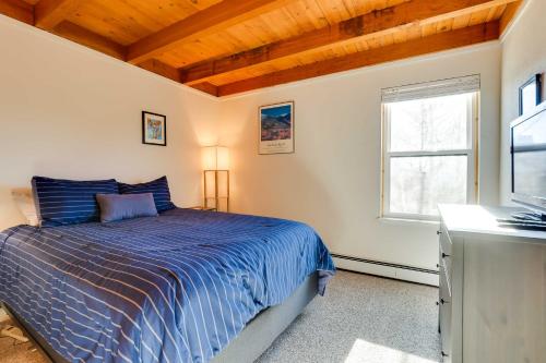 a bedroom with a blue bed and a window at Mtn-View Condo with Community Perks in Silverthorne in Silverthorne