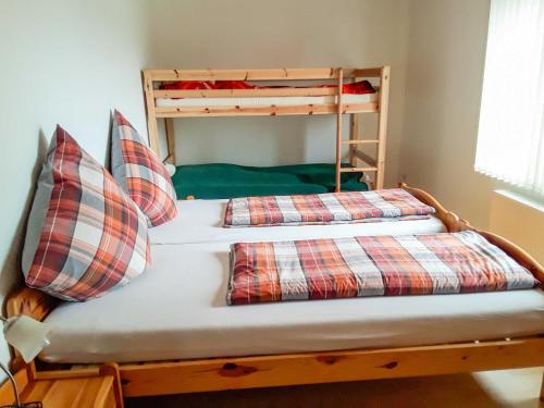 1 Bett mit 2 Etagenbetten mit Kissen in der Unterkunft Ferienwohnungen Fleesensee in Malchow