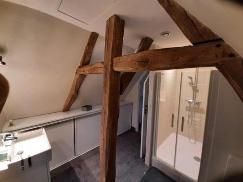 ein Badezimmer mit einem großen Holzkreuz an der Decke in der Unterkunft Gîte des châteaux de la Loire in Villandry