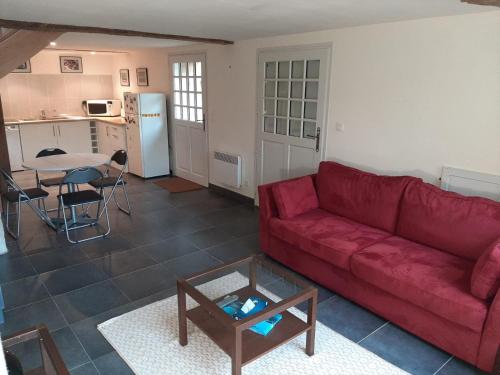 a living room with a red couch and a table at Gîte des châteaux de la Loire in Villandry