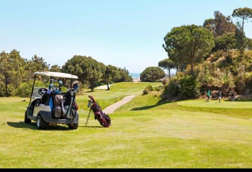 un carro de golf estacionado en un campo de golf en Lovely family house by the golf course, en Huelva