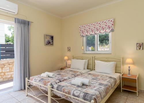 a bedroom with a bed with two pillows and a window at Amarlia Villa in Skaleta