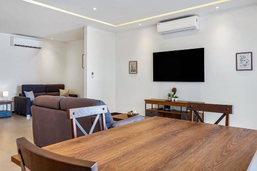 a living room with a table and a flat screen tv at V Golf 601 in Puerto Vallarta