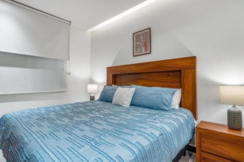 a bedroom with a bed with a wooden headboard and two lamps at V Golf 601 in Puerto Vallarta