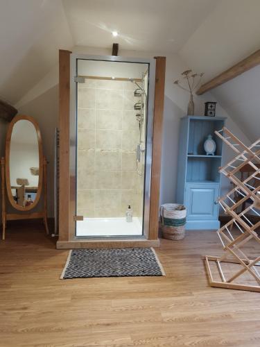 une douche avec une porte vitrée dans une pièce dans l'établissement Chalet des Roches Roche d'Oëtre Suisse Normande, à Saint-Philbert-sur-Orne