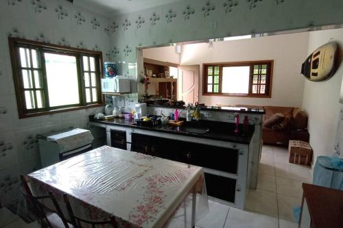 uma cozinha com uma mesa e uma bancada em Casa espaçosa à 100 m do mar em Mongaguá