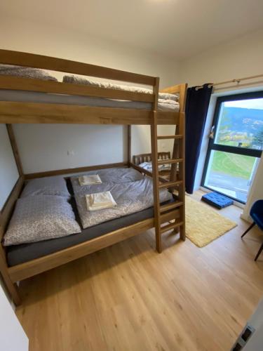 a bunk bed room with two bunk beds and a window at Apartmány v Javorné na Šumavě in Čachrov