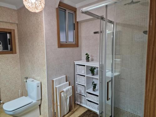 a bathroom with a toilet and a glass shower at Lovely Balaídos in Vigo