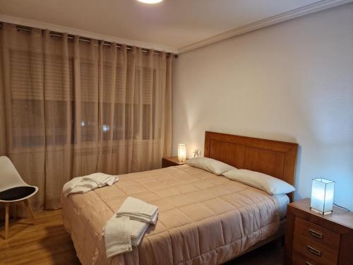 una camera con un grande letto e una finestra di Lovely Balaídos a Vigo