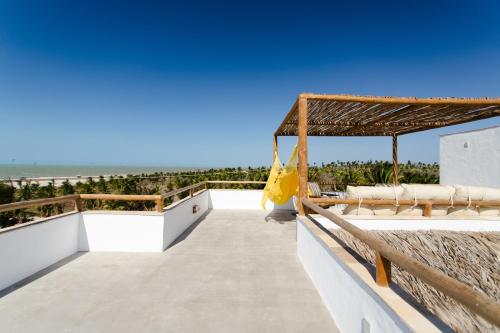 a view of the beach from the balcony of a house at Villa Aura, piscina privativa e rooftop com vista excepcional pro mar, 150m do mar e do Rancho do Kite, Praia do Prea in Prea