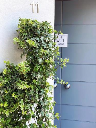 a bush next to a door with a sign on it at FWL Italian Romance on the Lake in Arona