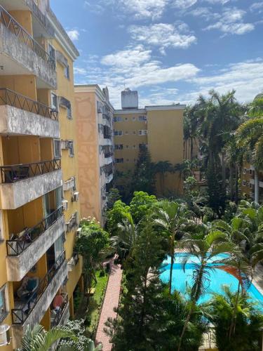 einen Luftblick auf ein Hotel mit einem Pool und Palmen in der Unterkunft Hospedagem para temporada in Recife