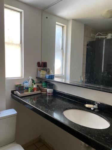 ein Bad mit einem Waschbecken und einem Spiegel in der Unterkunft Hospedagem para temporada in Recife