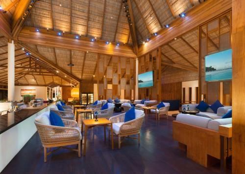 a lobby of a resort with couches and chairs at Conrad Maldives Rangali Island in Mandhoo
