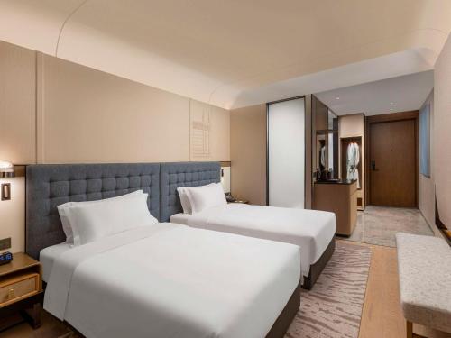 a hotel room with two beds and a kitchen at Swissôtel Hefei Grand Park in Hefei