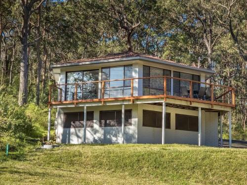 a large house with a deck on top of it at Sojourn at the Cove - opposite Heros Beach in North Arm Cove