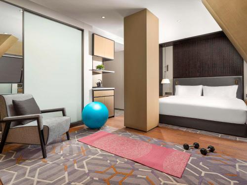 a bedroom with a bed and a living room at Swissôtel Hefei Grand Park in Hefei