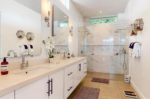 a white bathroom with two sinks and a shower at La Quinta Cove Retreat in La Quinta
