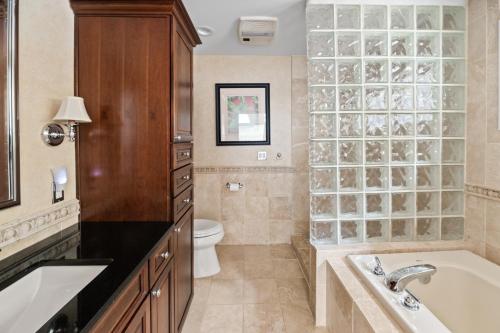 a bathroom with a tub and a toilet and a sink at East Quogue House in East Quogue
