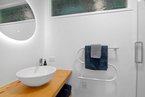 a bathroom with a white sink and a mirror at Maratoa - Takaka Holiday Home in Takaka