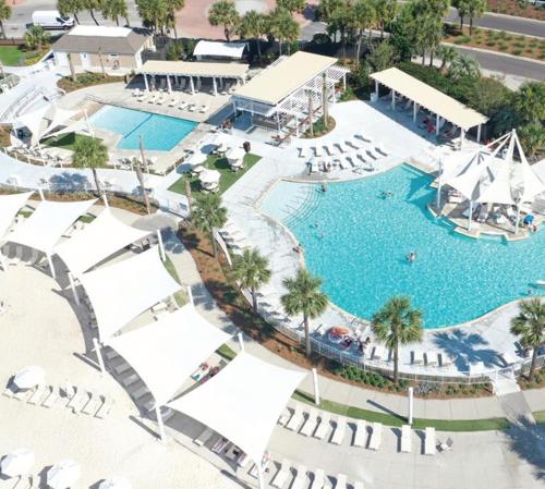 an overhead view of a swimming pool with white umbrellas at 1314 Pelican Watch - Seabrook Island - Beachfront 5 Star Condo - Fido Friendly in Seabrook Island