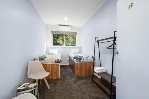 a small room with two beds and a chair at Bright Accommodation Park in Bright