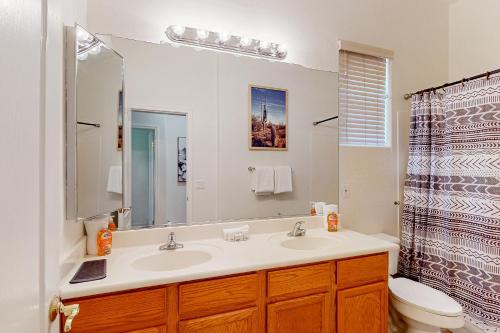 a bathroom with a sink and a toilet and a mirror at Serenity Now in Glendale