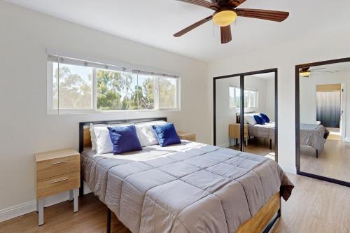 ein Schlafzimmer mit einem großen Bett und einem Deckenventilator in der Unterkunft The Cliffside Bungalow in San Diego