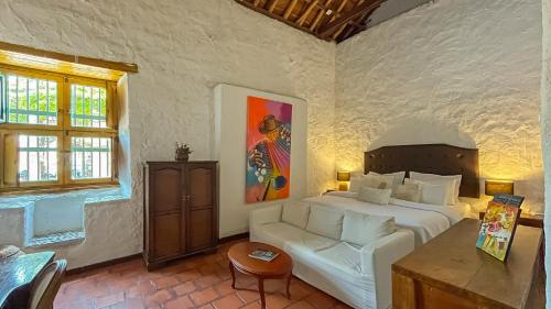 - une chambre avec un lit, un canapé et une table dans l'établissement Hotel Boutique Casa de Los Santos Reyes Valledupar, à Valledupar
